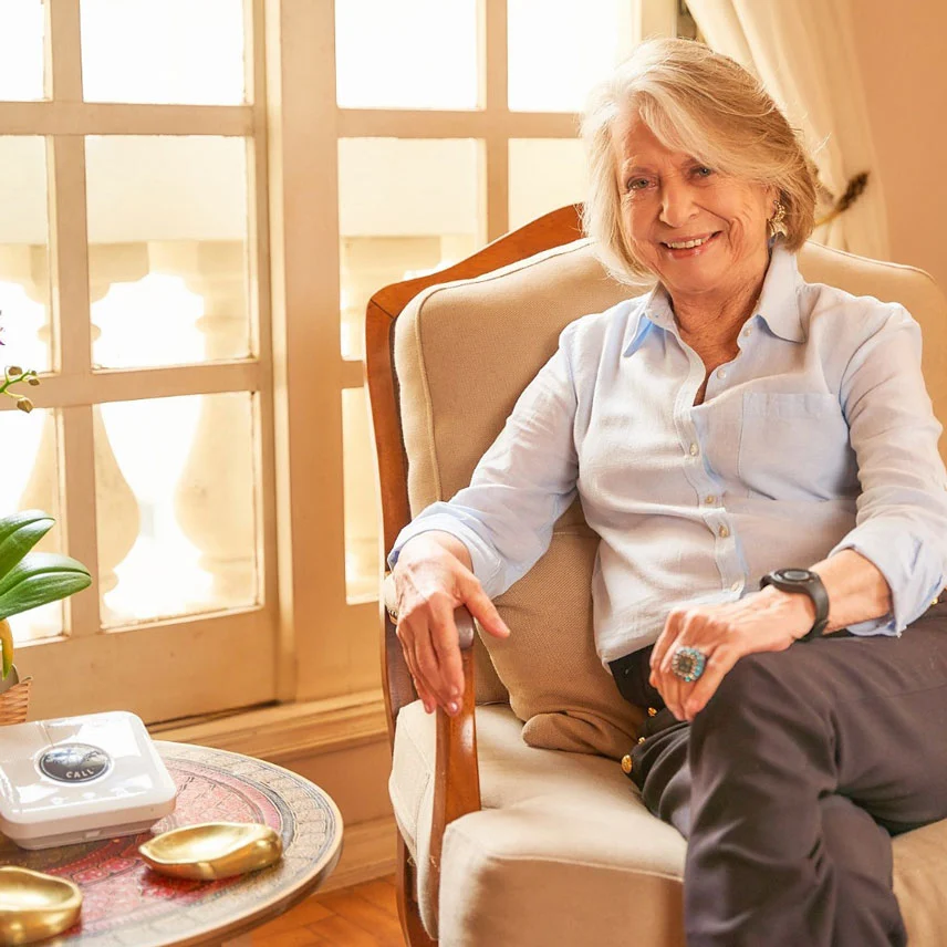 Dona Helena sorrindo na cozinha enquanto segue sua rotina.